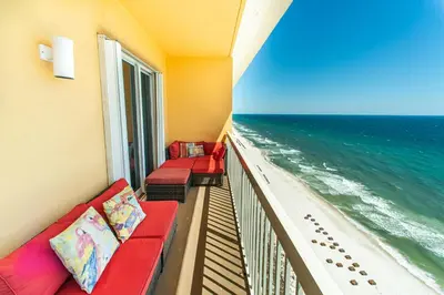 a balcony with two red couches and the ocean at Calypso 2-2304 West in Panama City Beach