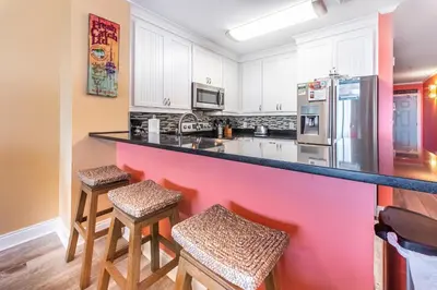 a kitchen with a counter and stools in it at Calypso 2-2304 West in Panama City Beach