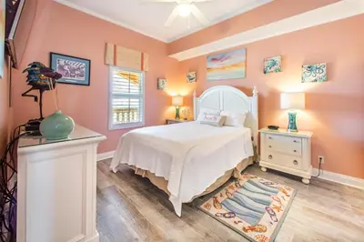 a bedroom with a white bed and a white dresser at Calypso 2-2304 West in Panama City Beach