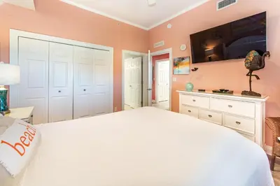 a bedroom with a white bed and a tv on the wall at Calypso 2-2304 West in Panama City Beach