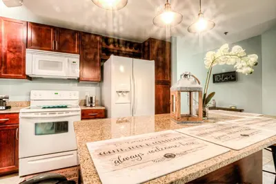 a kitchen with a white refrigerator and a counter top at Laketown Wharf 534 By Aneliya in Panama City Beach