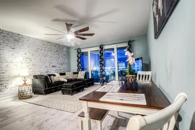 a living room with a table and a ceiling fan at Laketown Wharf 534 By Aneliya in Panama City Beach