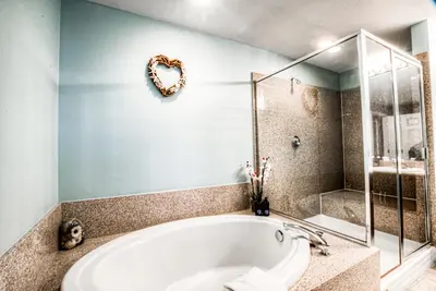 a bath tub in a bathroom with a heart shaped mirror at Laketown Wharf 534 By Aneliya in Panama City Beach