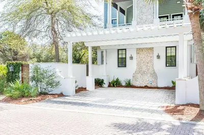 a white house with a white fence and a driveway at Stay Salty in Santa Rosa Beach