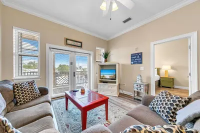 a living room with two couches and a tv at Churchill By The Sea 2308 in Santa Rosa Beach