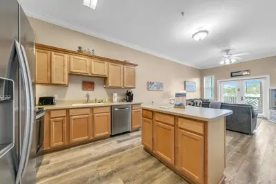 a kitchen with wooden cabinets and stainless steel appliances at Churchill By The Sea 2308 in Santa Rosa Beach