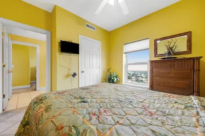 a bedroom with a large bed with yellow walls at Ocean Reef 1709 in Panama City Beach