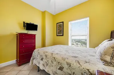 a bedroom with a bed and a dresser and a window at Ocean Reef 1709 in Panama City Beach