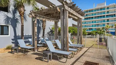 a gazebo with blue chairs and palm trees at Ocean Reef 1709 in Panama City Beach