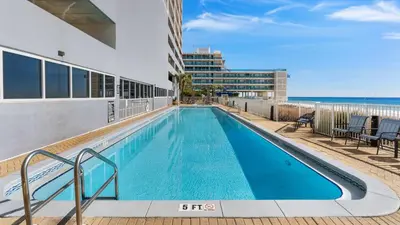 a swimming pool on the side of a building with the beach at Ocean Reef 1709 in Panama City Beach