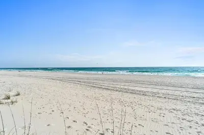 a beach with footprints in the sand and the ocean at Harbur Arms - Pet Friendly in Panama City Beach