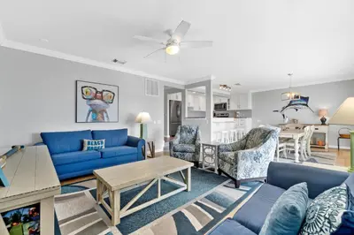 a living room with blue couches and a table at Harbur Arms - Pet Friendly in Panama City Beach