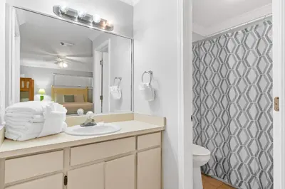 a bathroom with a sink and a mirror and a toilet at Harbur Arms - Pet Friendly in Panama City Beach