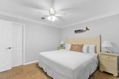 a white bedroom with a bed and a ceiling fan at Harbur Arms - Pet Friendly in Panama City Beach