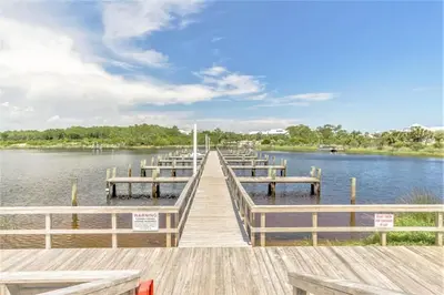 a dock with several boats on a lake at Pinnacle Port Beach Resort in Panama City Beach
