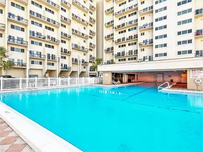 a large swimming pool in front of a building at Pinnacle Port Beach Resort in Panama City Beach