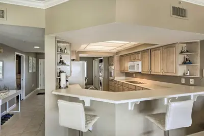 a kitchen with wooden cabinets and white appliances at Gulf Views and Pool Access Coral Reef Resort Condo in Panama City Beach
