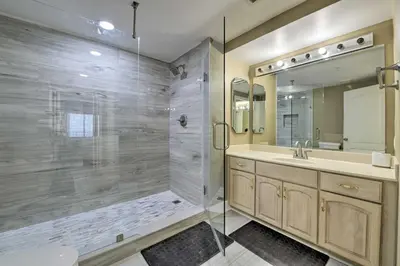 a bathroom with a shower and a sink and a mirror at Gulf Views and Pool Access Coral Reef Resort Condo in Panama City Beach
