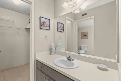 a white bathroom with a sink and a mirror at Aquavista 405e in Panama City Beach
