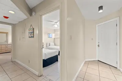 a bedroom with a bed and a room with a door at Aquavista 405e in Panama City Beach