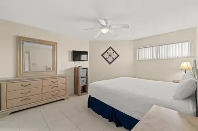 a bedroom with a bed and a mirror and a dresser at Aquavista 405e in Panama City Beach