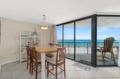 a dining room with a table and a view of the ocean at Aquavista 405e in Panama City Beach