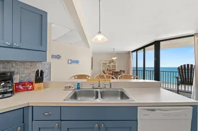 a kitchen with a sink and a view of the ocean at Aquavista 405e in Panama City Beach