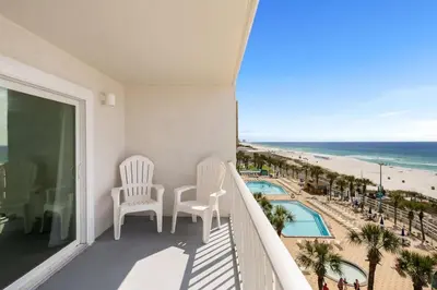 a balcony with chairs and a view of the beach at The Summit 606 in Panama City Beach