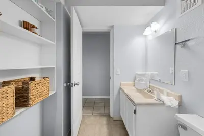 a white bathroom with a sink and a mirror at The Summit 606 in Panama City Beach