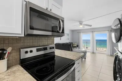 a kitchen with a microwave and a stove top oven at The Summit 606 in Panama City Beach