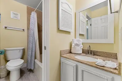 a bathroom with a toilet and a sink and a mirror at The Summit 1116 in Panama City Beach