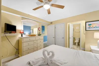 a bedroom with a white bed with a ceiling fan at The Summit 1116 in Panama City Beach