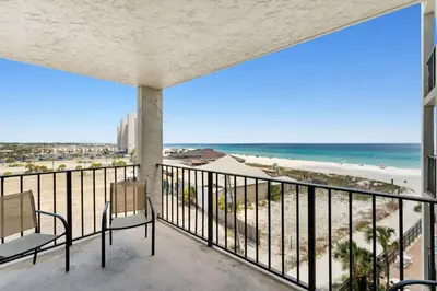 a balcony with two chairs and a view of the beach at Moondrifter 608 in Panama City Beach
