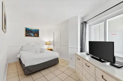 a bedroom with a bed and a flat screen tv at Moondrifter 608 in Panama City Beach