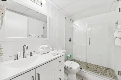a white bathroom with a toilet and a shower at Moondrifter 608 in Panama City Beach