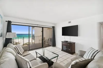 a living room with a couch and a flat screen tv at Moondrifter 608 in Panama City Beach