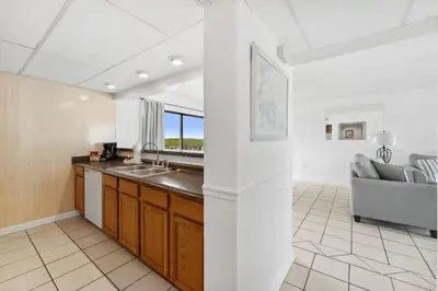 a kitchen with a sink and a couch in a room at Moondrifter 608 in Panama City Beach