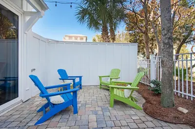 three chairs and a table on a patio at Aqua Blue in Inlet Beach