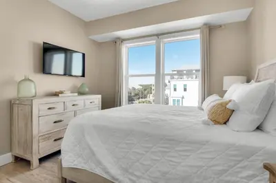 a bedroom with a large white bed and a window at Aqua Blue in Inlet Beach