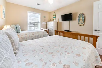 a bedroom with a bed and a dresser and a television at Beachside Villas 332 in Santa Rosa Beach