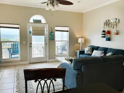a living room with a blue couch and a view of the ocean at Vista del Mar I Ocean Overlook 302 in Panama City Beach