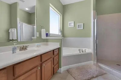 a bathroom with a tub and a sink and a shower at Vista del Mar I Ocean Overlook 302 in Panama City Beach