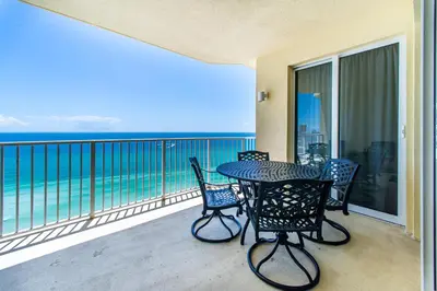 a balcony with a table and chairs and the ocean at Boardwalk 1502 in Panama City Beach