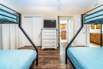 a bedroom with two bunk beds and a tv at Boardwalk 1502 in Panama City Beach