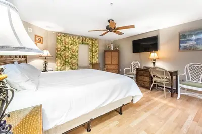 a bedroom with a bed and a desk and a television at Tidewater 502 in Panama City Beach