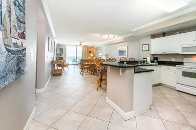 a kitchen and dining room with a view of the ocean at Tidewater 502 in Panama City Beach
