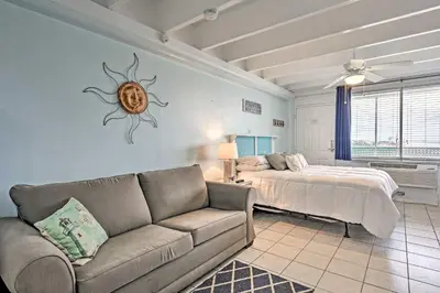 a living room with a couch and a bed at Panama City Beach Studio with Pool and Beach Access in Panama City Beach