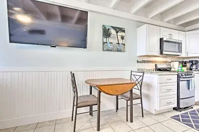 a kitchen with a table and two chairs and a counter at Panama City Beach Studio with Pool and Beach Access in Panama City Beach