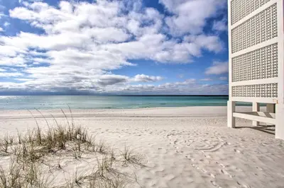 a chair sitting on a beach with the ocean at Panama City Beach Studio with Pool and Beach Access in Panama City Beach