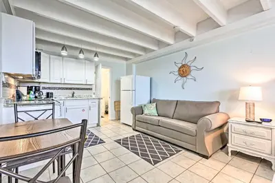 a living room with a couch and a table and a kitchen at Panama City Beach Studio with Pool and Beach Access in Panama City Beach